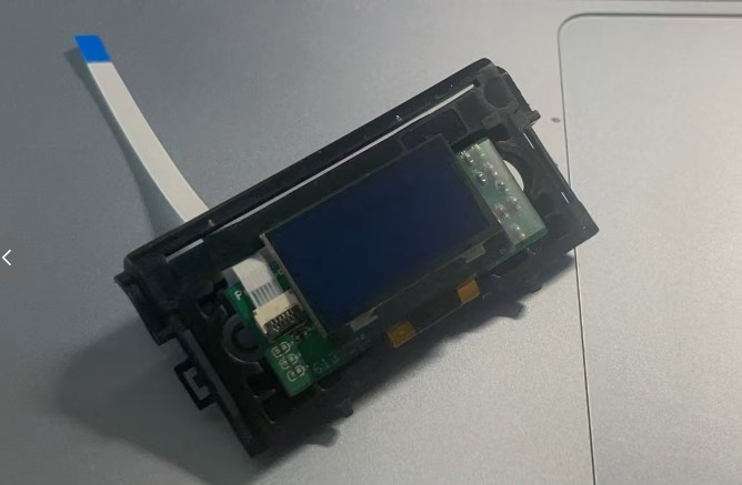OLED 模块放入触摸板壳内部，排线从壳体一侧引出。